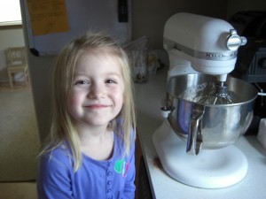 Isabelle helping make birthday cupcakes